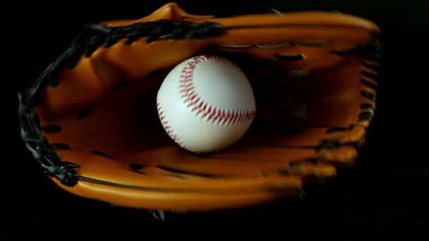 Guante de béisbol y pelota sobre fondo negro, cámara lenta
 - Imágenes, Vídeo