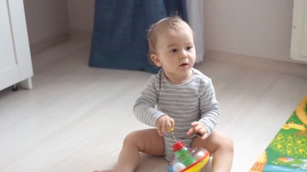 Lindo bebé jugando con juguetes coloridos en casa
 - Metraje, vídeo