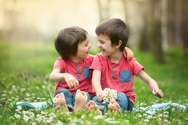 Happy little children, lying in the grass, barefoot, daisies aro - Foto, Imagen