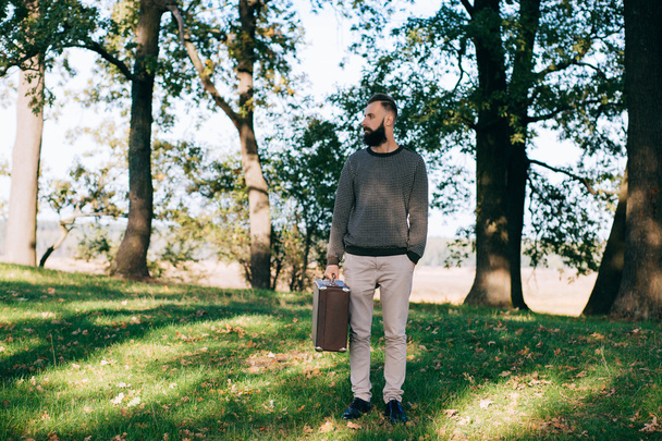Bearded hipster man with retro suitcase - Foto, afbeelding