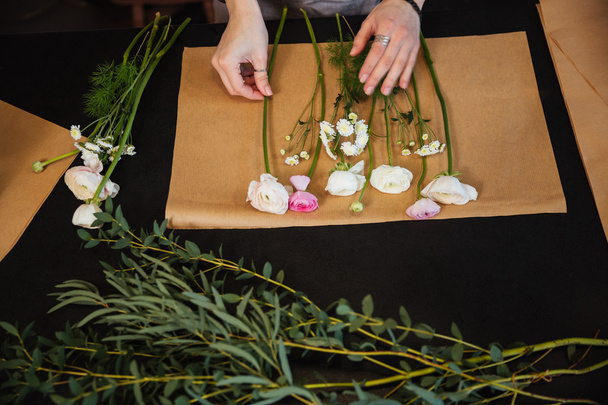 Hands of woman florist choosing flowers and making boquet  - Foto, imagen
