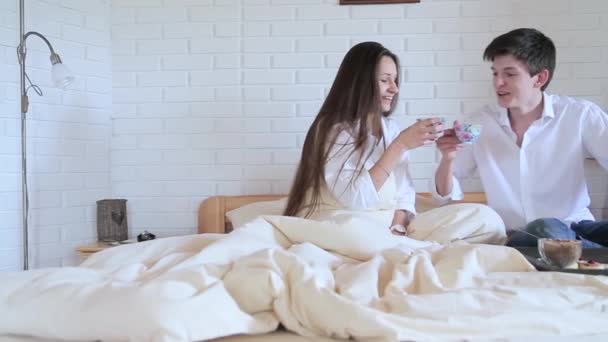 Couple drinking tea in bed in the loft room - Záběry, video