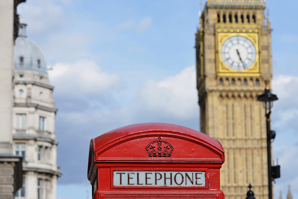 Vista della tradizionale cabina telefonica rossa britannica con la torre dell'orologio
  - Foto, immagini