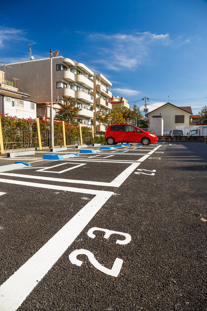 Parkeerplaats met rode auto - Foto, afbeelding