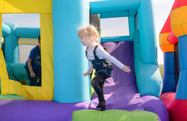 Pretty little blond girl playing on a slide - Photo, Image