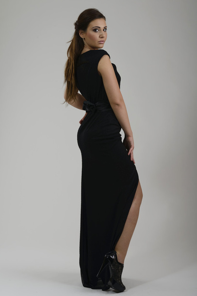 Elegant woman in fashionable dress posing in the studio - 写真・画像