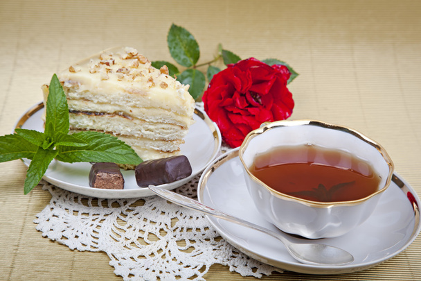 Νομισματοκοπείο τσάι και κέικ σε μια χαρτοπετσέτα δαντέλα - Φωτογραφία, εικόνα