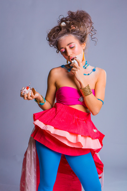 Beautiful girl eats chokolate creamy muffin with cherry - Zdjęcie, obraz