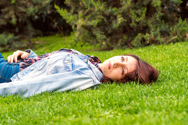 красива молода жінка відпочиває на траві
 - Фото, зображення