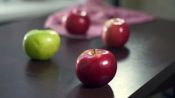 Ręka wziąć czerwone jabłka z drewnianego stołu. Świeże owoce. Kuchnia wegetariańska - Materiał filmowy, wideo
