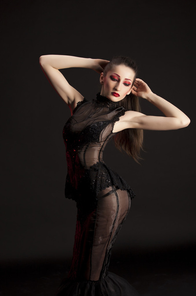 Retrato de hermosa joven morena en vestido negro sobre fondo oscuro, resaltado con rojo
 - Foto, imagen