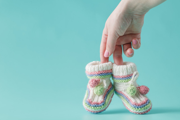 female hand holds small baby shoes - Fotografie, Obrázek