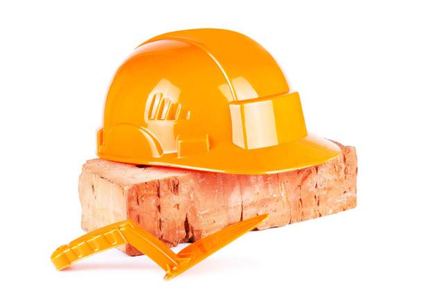 Oranje bouw helm met baksteen - Foto, afbeelding