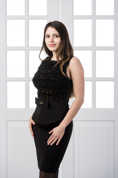 fröhliche Mode Modell schwarzes Kleid posiert und lächelt im Studio Loft Home Innentüren hinter - Foto, Bild