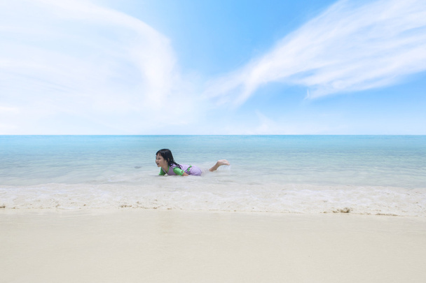 Happy little girl playing on the tropical beach - Fotoğraf, Görsel