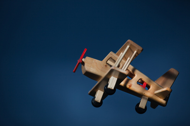 Holzflugzeug fliegt in der Dämmerung - Seitenansicht - Foto, Bild