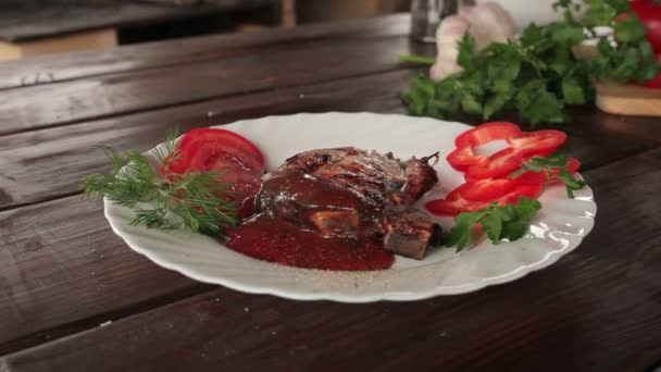 Nagy lédús grillezett steak zöldekkel a tányéron - Felvétel, videó