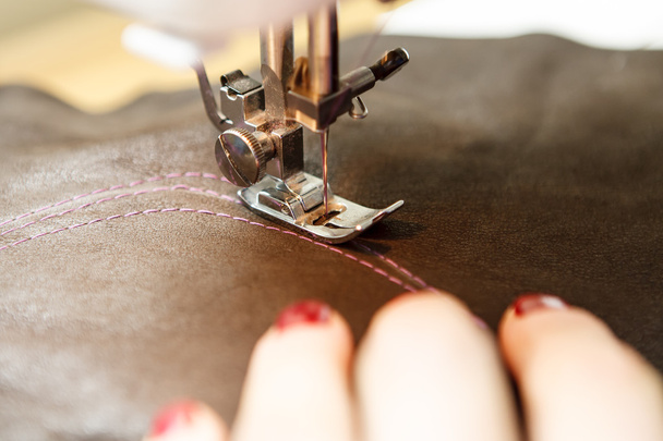 Women's hands behind her sewing. Sewing process with leather - 写真・画像