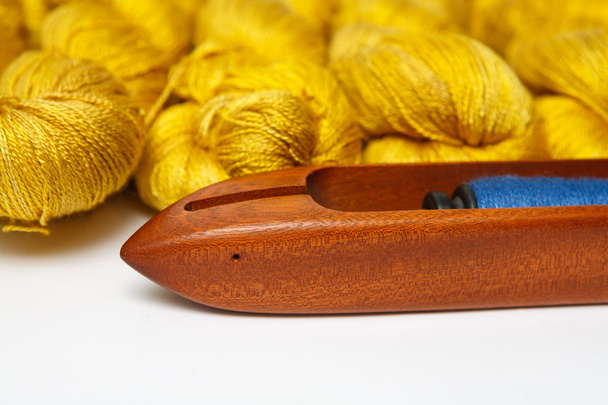 Navette de tissage avec fils colorés pour aiguilles isolées sur blanc
 - Photo, image