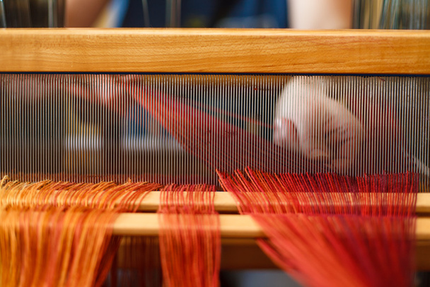 Руки женщины, которая плетет на ткацком станке
 - Фото, изображение