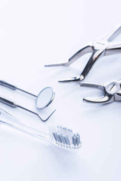 Основные стоматологические инструменты на белом столе
 - Фото, изображение