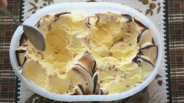Yellow ice cream takes out of the container - Video
