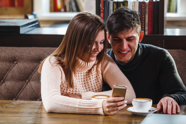 couple  in cafe looking at smartphone - Photo, Image
