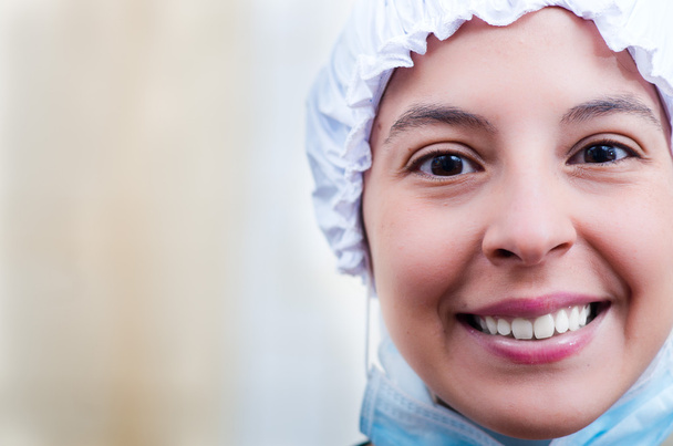 Closeup headshot female nurse wearing bouffant cap and smiling happily for camera - Foto, afbeelding