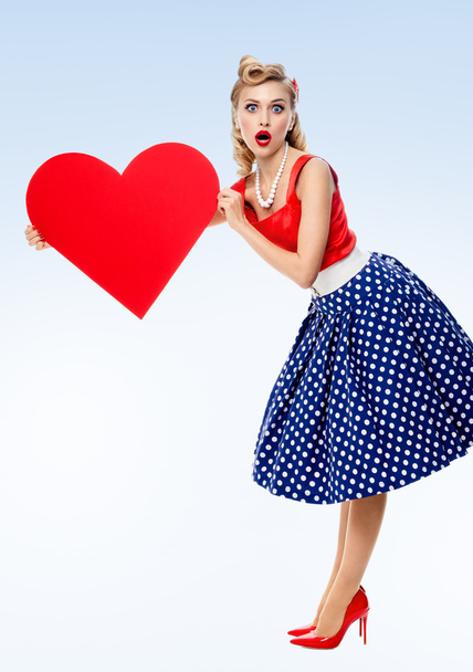 smiling woman holding heart symbol, dressed in pin-up style - Foto, Bild