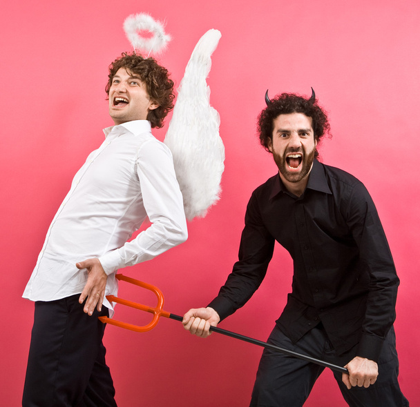 funny white angel and black devil joke together isolated on pink - Fotó, kép