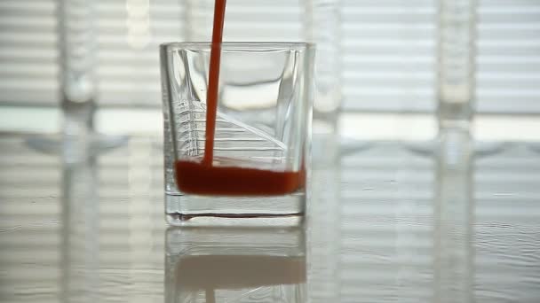 Tomato juice is poured into a glass. close-up - Metraje, vídeo