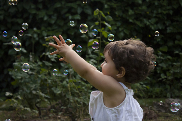 Fille jouer avec des bulles de savon dans le jardin
 - Photo, image