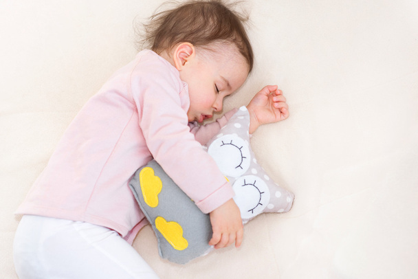 Mały dziecko dziewczynka maluch śpi piękny z zabawkami sowa - Zdjęcie, obraz