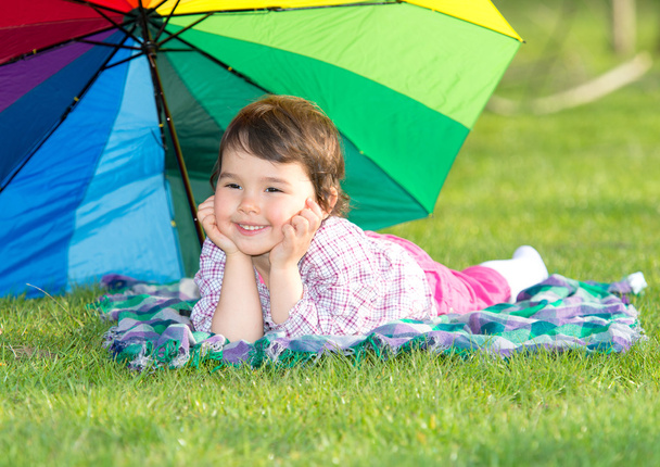 boldog kislány egy szivárvány esernyő-parkban - Fotó, kép