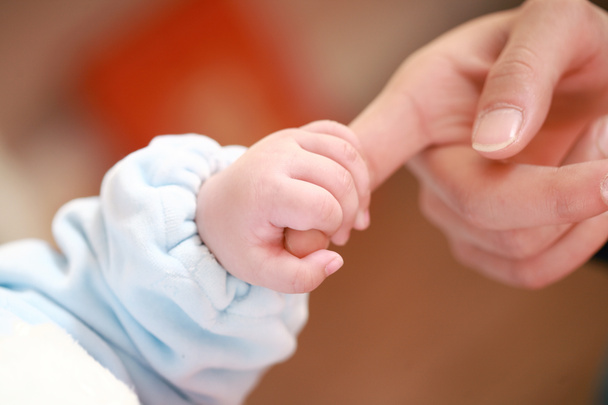 Baby holding mother's finger - Φωτογραφία, εικόνα