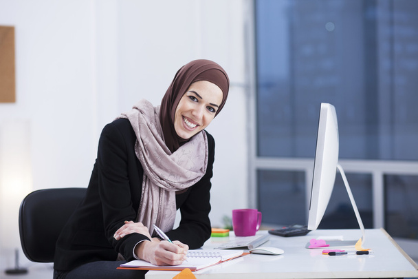 Beautiful Arabic business woman working on computer. Woman in her office - Фото, изображение