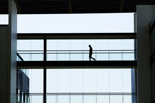Vista de la silueta del joven empresario en un moderno edificio de oficinas interior
 - Foto, imagen