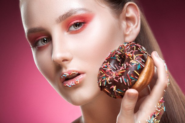 Fashion-portrait of the young girl with a donut. - Photo, image