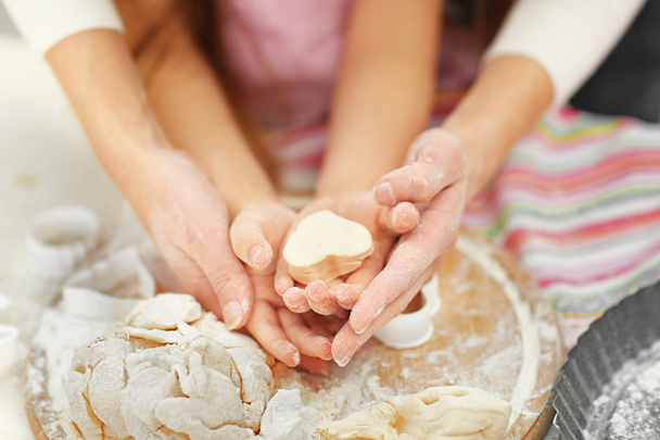 Mother and daughter cutting cookie shapes - Photo, image