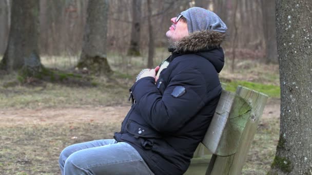 Homme avec Bible et chapelet priant sur le banc dans le parc
  - Séquence, vidéo