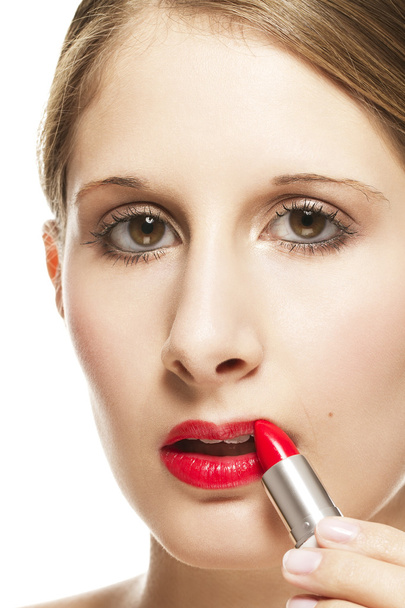 Closeup of a beautiful woman applying lipstick - Foto, afbeelding