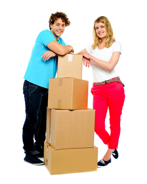 Teenager couple posing beside cardboard boxes - Photo, image