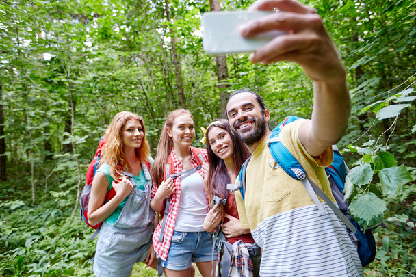 friends with backpack taking selfie by smartphone - Foto, Bild