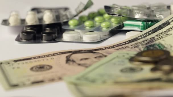 Σωρού φαρμακευτική ναρκωτικών και ιατρικής χάπια διάσπαρτα στο δολάριο μετρητά χρήματα, το κόστος του φαρμακευτικού προϊόντος και θεραπείας έννοια - Πλάνα, βίντεο