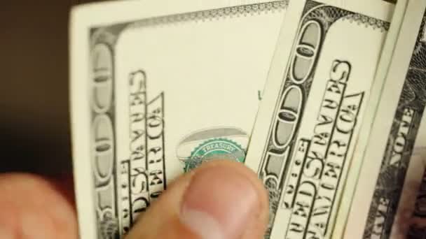 Gros plan d'un homme d'affaires mains comptant des billets de cent dollars à une table
 - Séquence, vidéo