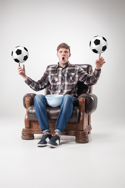The portrait of fan with balls, holding dish on gray background - Foto, Imagem