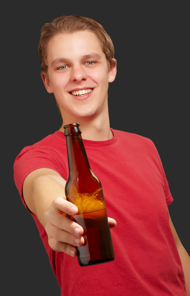 retrato de un joven sosteniendo cerveza sobre un fondo negro
 - Foto, imagen