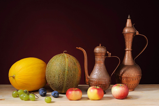 Metal jug, melons and fruits on the table - Photo, Image