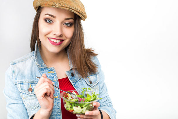 Mujer comiendo ensalada saludable del recipiente de plástico
 - Foto, imagen
