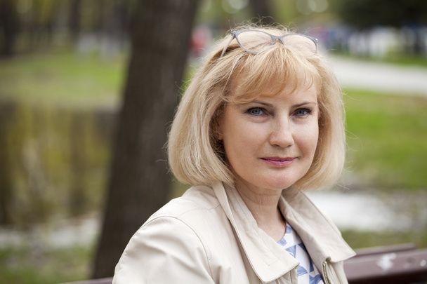 Portrait of lovely middle aged woman in the summer park  - Fotó, kép